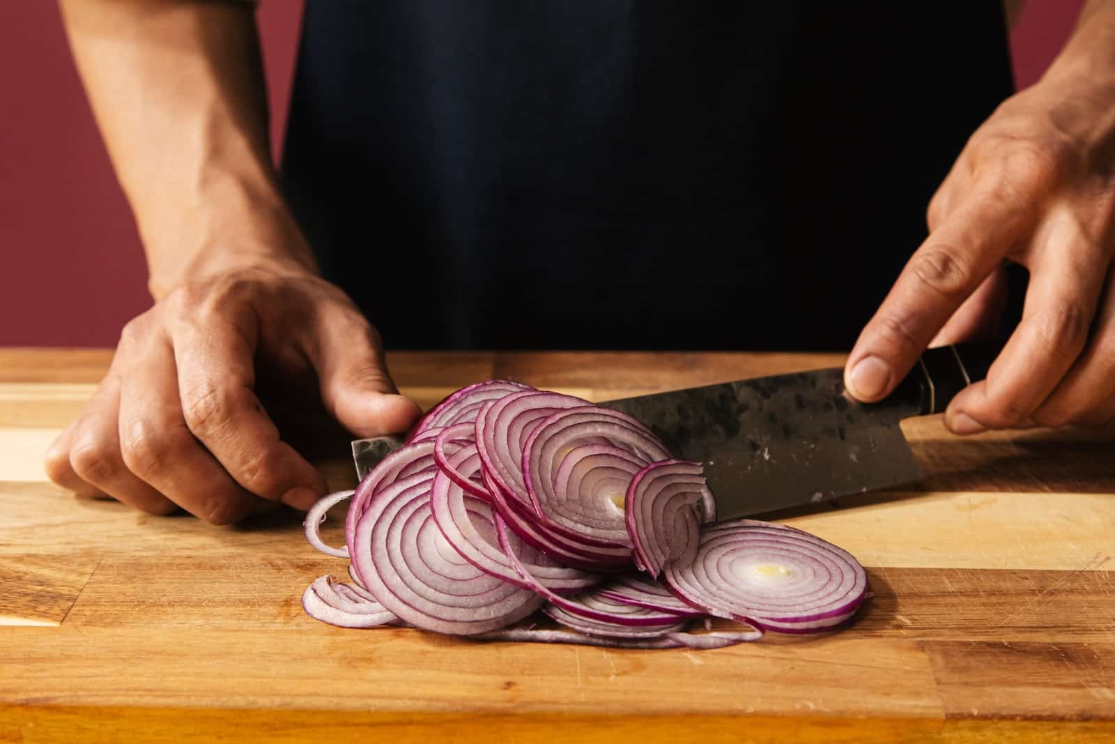 A Person Cutting an Onion Thinly