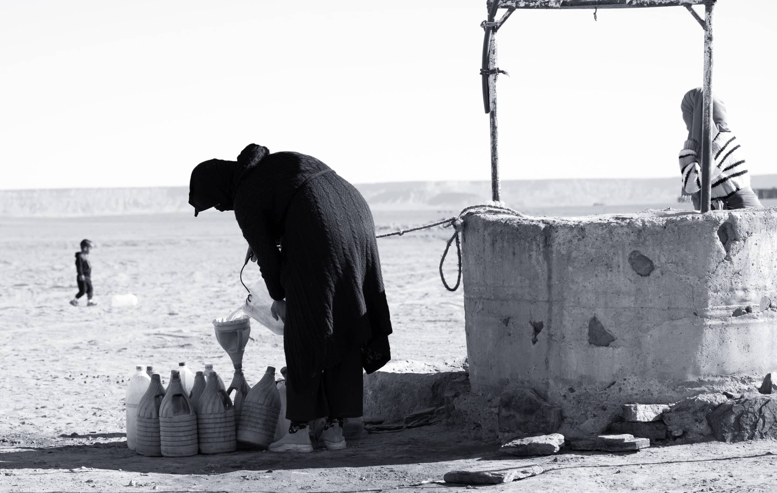 family drawing water from well desert merzouga morocco scaled